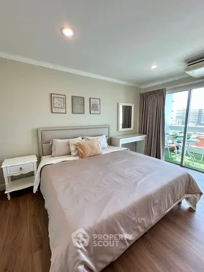 Spacious bedroom with elegant decor and balcony access in modern apartment.