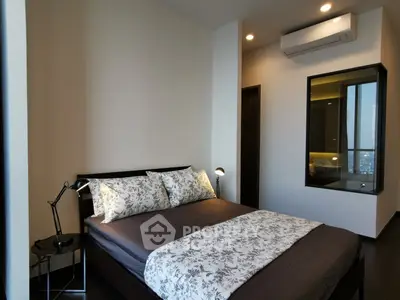 Modern bedroom with stylish decor and city view, featuring a cozy bed and sleek lighting.