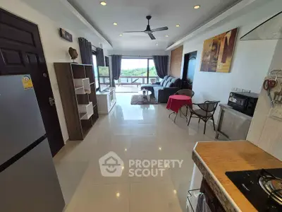 Spacious open-plan living room with modern kitchen and scenic balcony view.