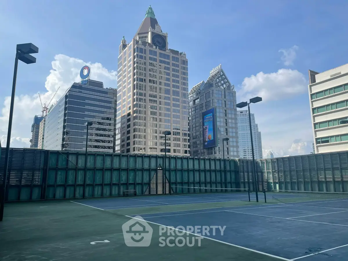 Stunning rooftop tennis court with city skyline views, perfect for urban living enthusiasts.