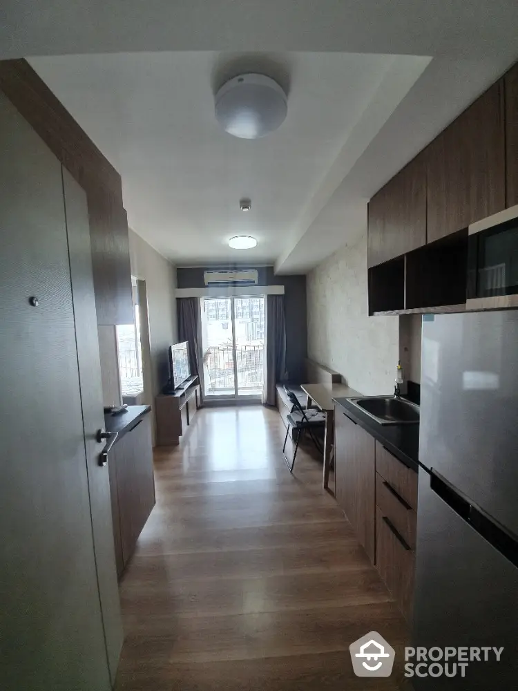 Modern studio apartment with open kitchen and balcony view