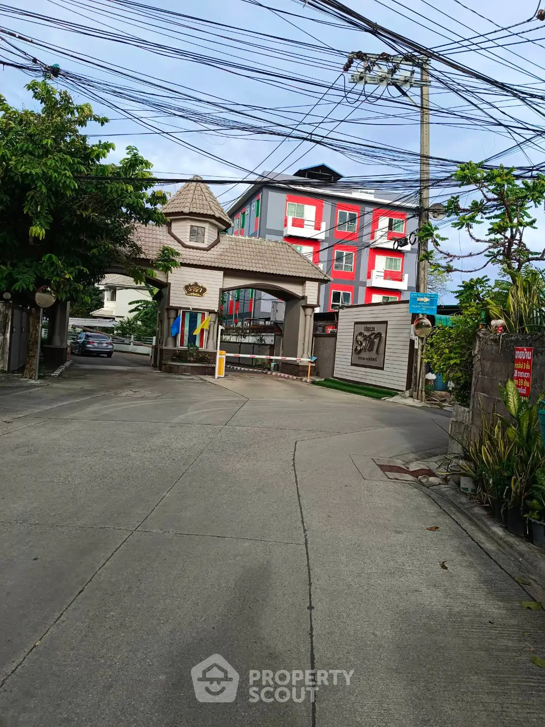 Charming residential entrance with colorful building facade and lush greenery.