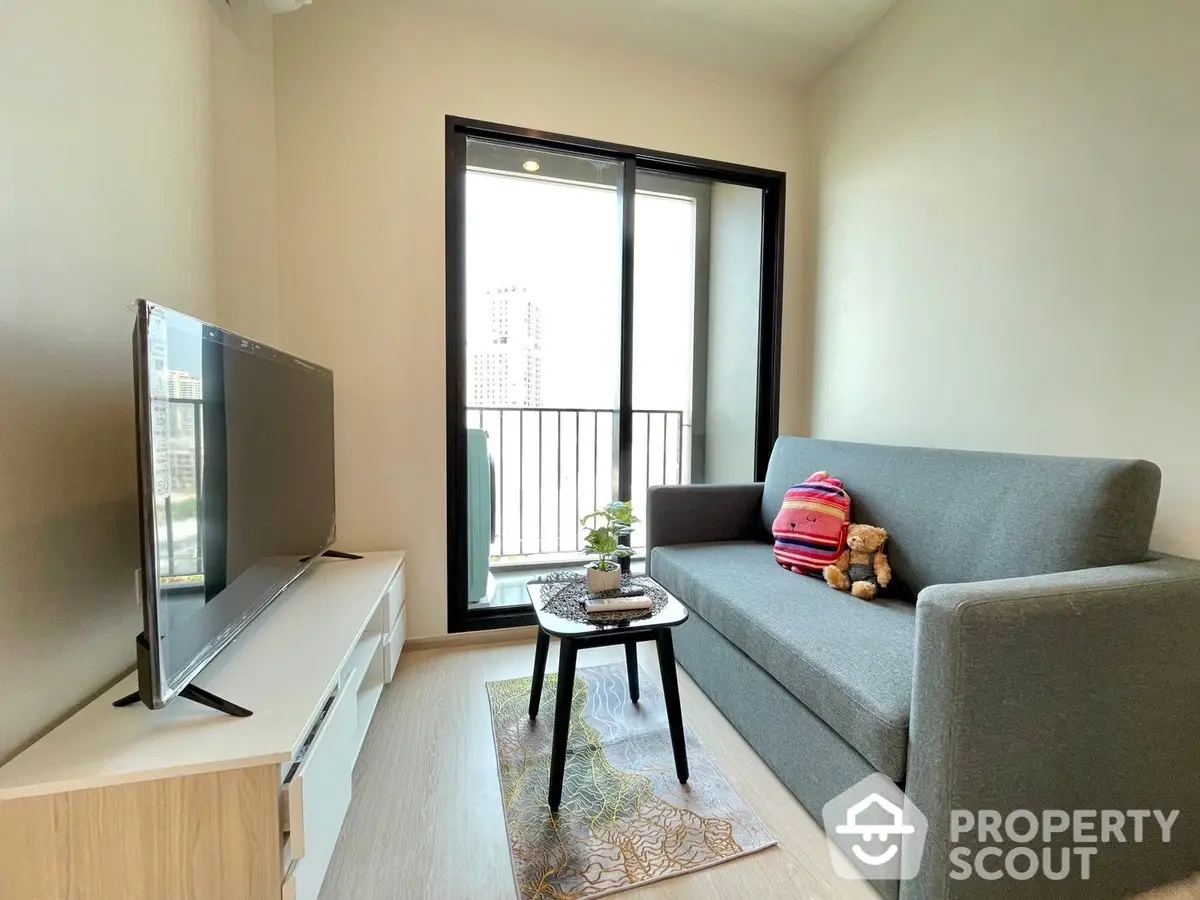 Bright and inviting living room with modern furnishings, large windows leading to a cozy balcony with an urban view, perfect for relaxation.