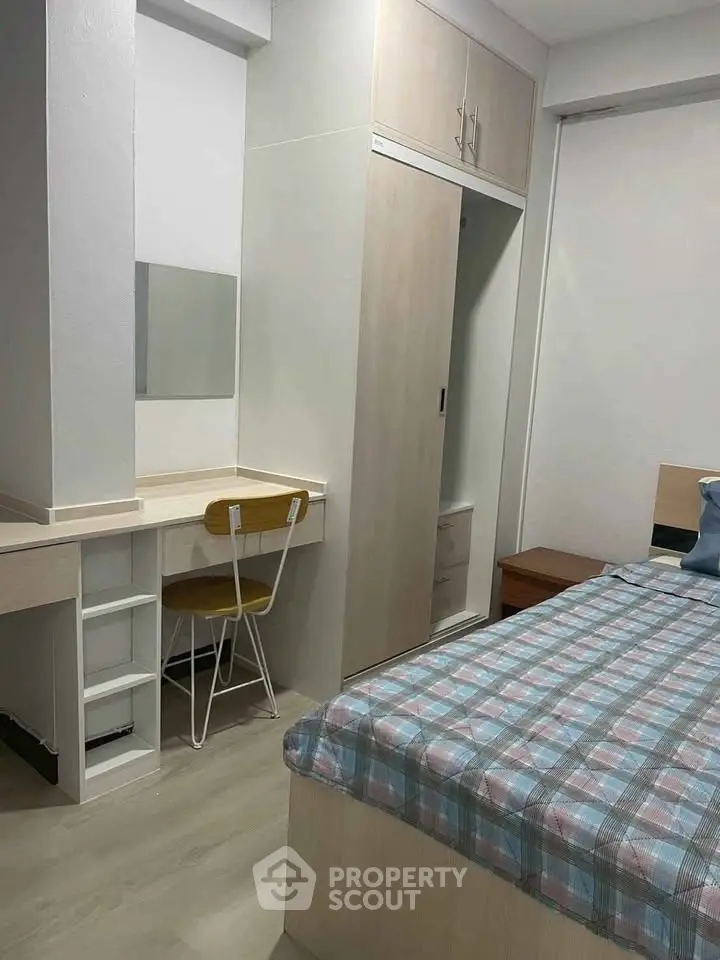 Cozy bedroom with built-in wardrobe and study desk, perfect for modern living.