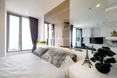 Modern bedroom with elegant decor and large windows offering natural light.