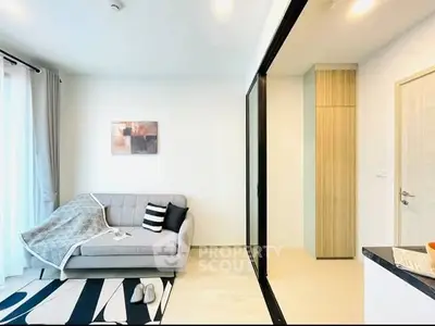 Modern living room with stylish sofa and abstract art, featuring sleek design and natural light.