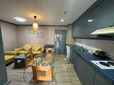 Modern open-plan living room and kitchen with stylish decor and cozy seating area.