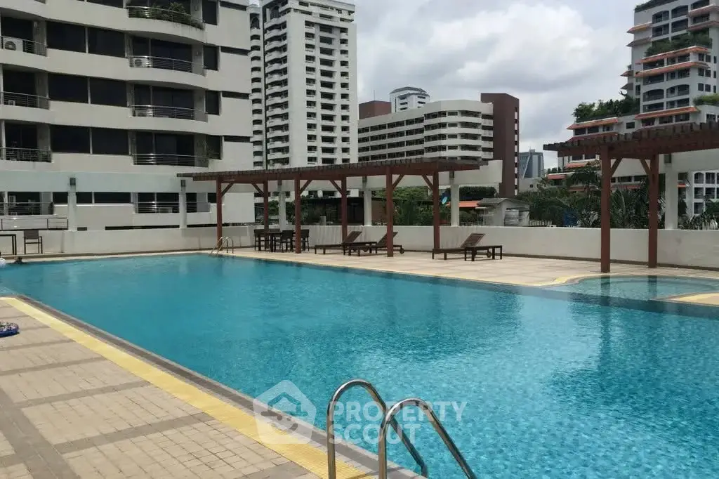 Luxurious apartment complex with spacious outdoor pool and modern architecture.