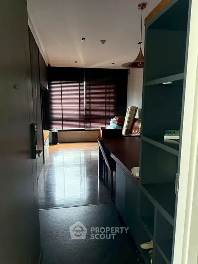 Cozy living room with modern furnishings and large window blinds.