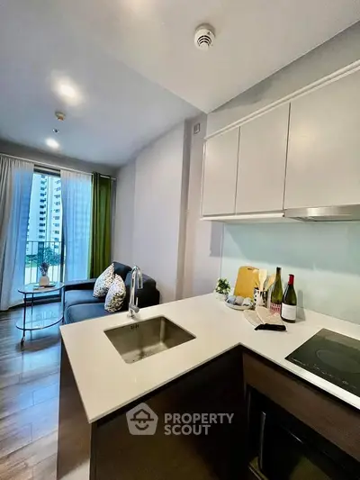 Modern open-layout kitchen with sleek design and cozy living area, perfect for urban living.