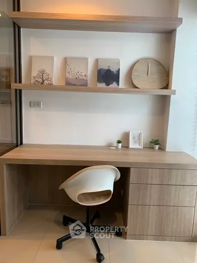 Modern study area with sleek wooden desk, stylish chair, and decorative shelves in a contemporary home.