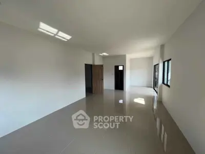Spacious modern living room with large windows and glossy tiled floors
