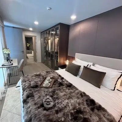 Luxurious bedroom with plush bedding and walk-in closet, perfect for modern living.