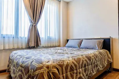 Cozy bedroom with elegant curtains and stylish bedding in a modern apartment.
