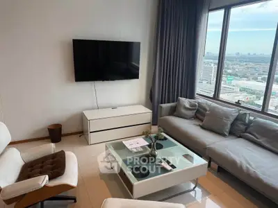 Modern living room with city view, sleek furniture, and large windows for natural light.