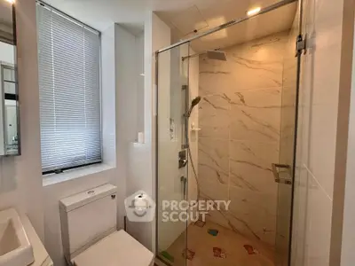 Modern bathroom with glass shower and marble tiles