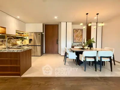 Luxurious open-layout kitchen and dining area with modern decor and elegant lighting.