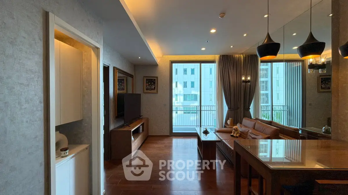 Spacious modern living room with elegant decor and large windows offering natural light and city views.