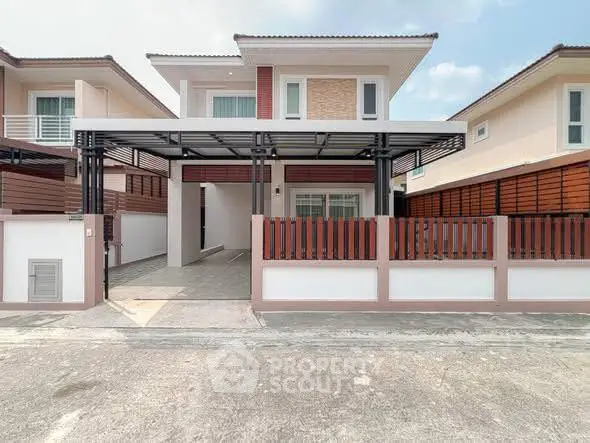 Modern two-story house with spacious driveway and stylish fence