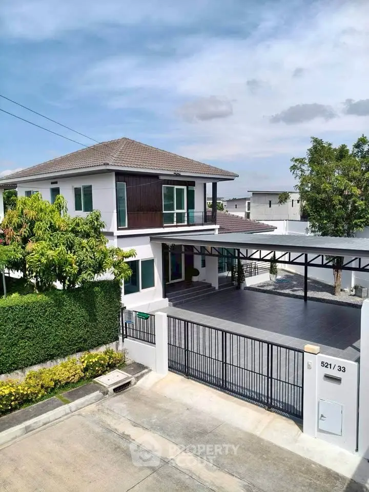 Modern two-story house with spacious driveway and lush greenery in a serene neighborhood.