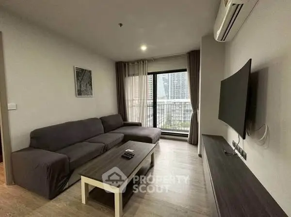 Modern living room with sleek furniture and city view balcony in high-rise apartment.