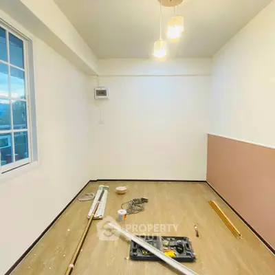 Minimalist room under renovation with wooden flooring and modern lighting