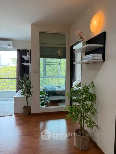 Modern apartment interior with wooden flooring, large window, and stylish decor.