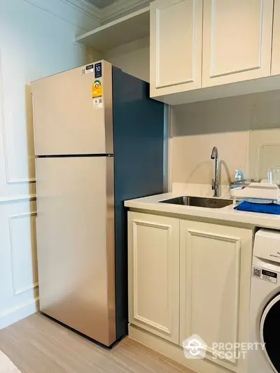 Modern kitchen with stainless steel fridge and washing machine