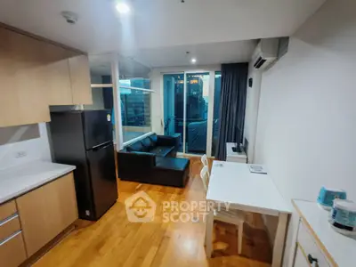 Modern open-plan living room with kitchen and balcony view in urban apartment