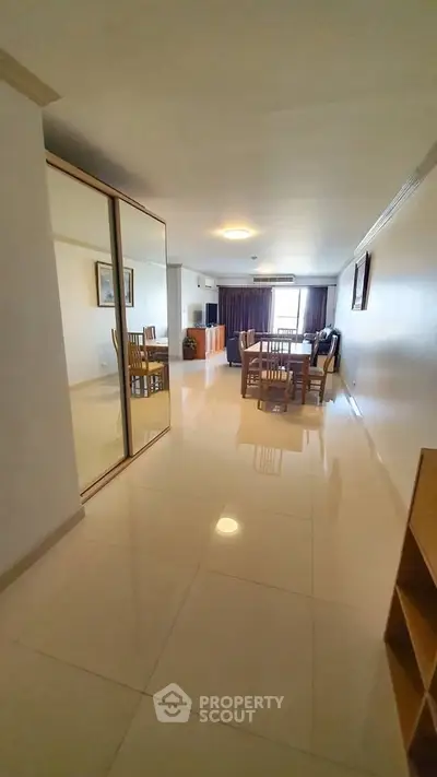 Spacious living room with dining area and large windows for natural light.