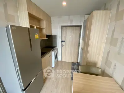 Modern compact kitchen with fridge and washing machine in stylish apartment