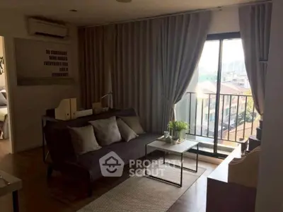 Chic living room with balcony view, modern decor, and ample natural light in urban apartment.