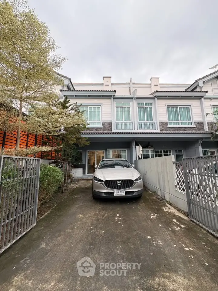 Charming townhouse with driveway and modern facade in a serene neighborhood.