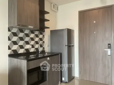 Modern compact kitchen with geometric backsplash and sleek appliances