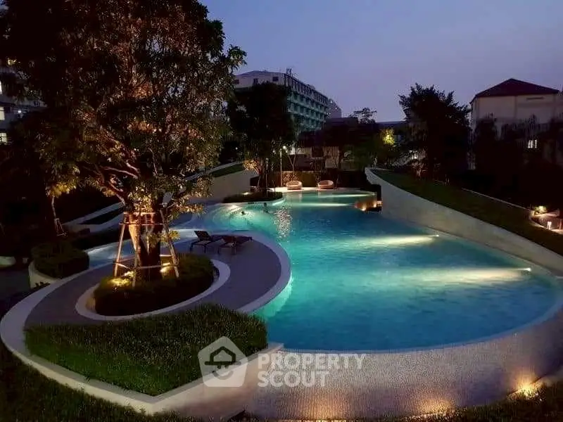 Luxurious evening poolside view with ambient lighting in a serene residential complex.