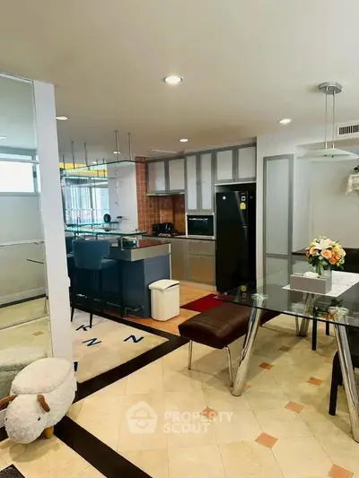 Modern open-layout kitchen and dining area with sleek appliances and stylish decor.