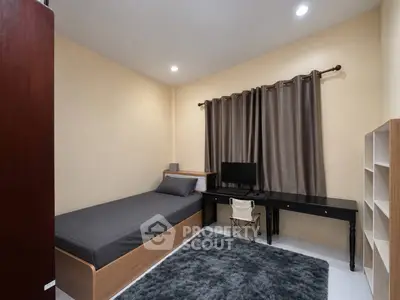 Cozy bedroom with single bed, desk, and modern decor in a well-lit space.