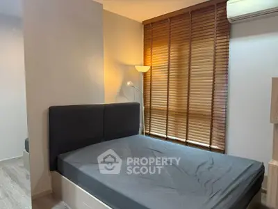 Cozy bedroom with modern design and natural light through wooden blinds.