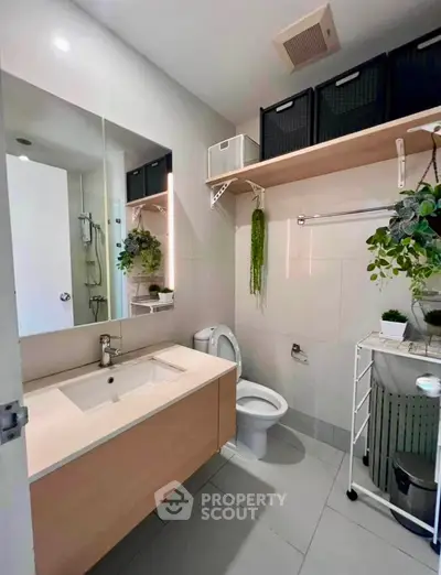 Modern bathroom with sleek vanity, wall-mounted storage, and stylish decor.