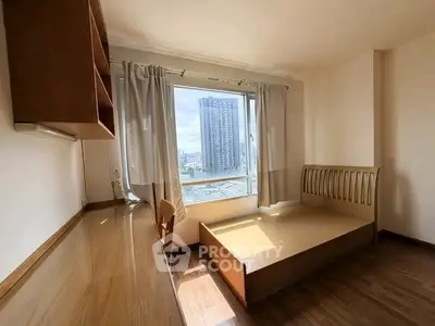 Bright bedroom with city view, wooden furniture, and large window in modern apartment.