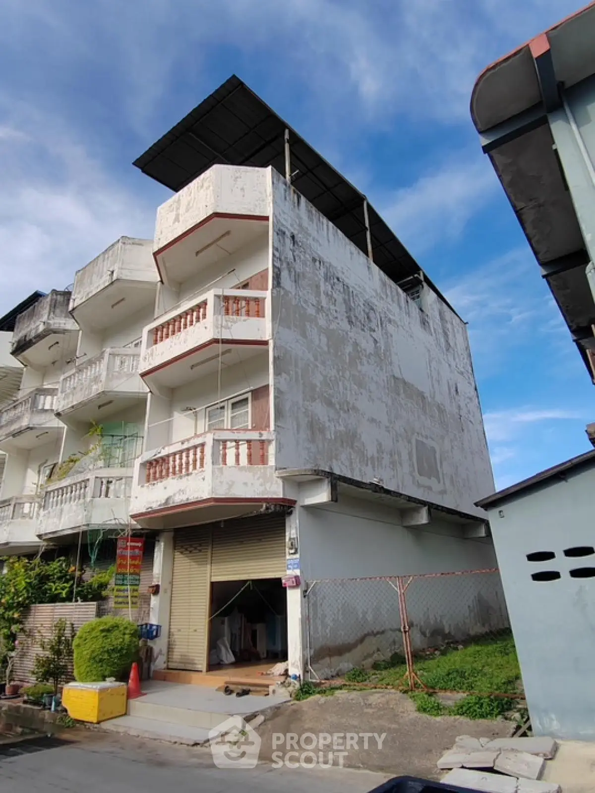 Spacious multi-story building with balconies and potential for renovation in a residential area.