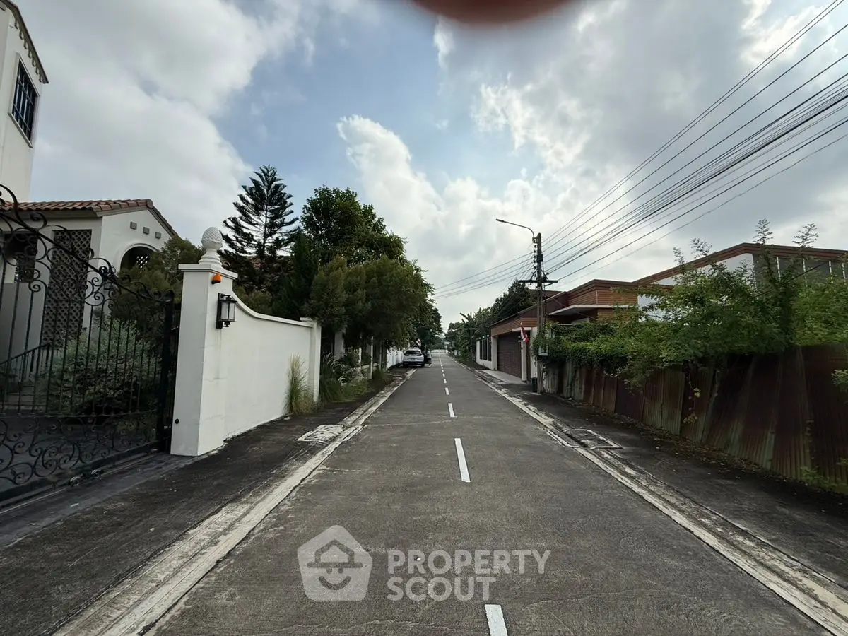 Charming residential street with lush greenery and elegant homes, perfect for serene living.