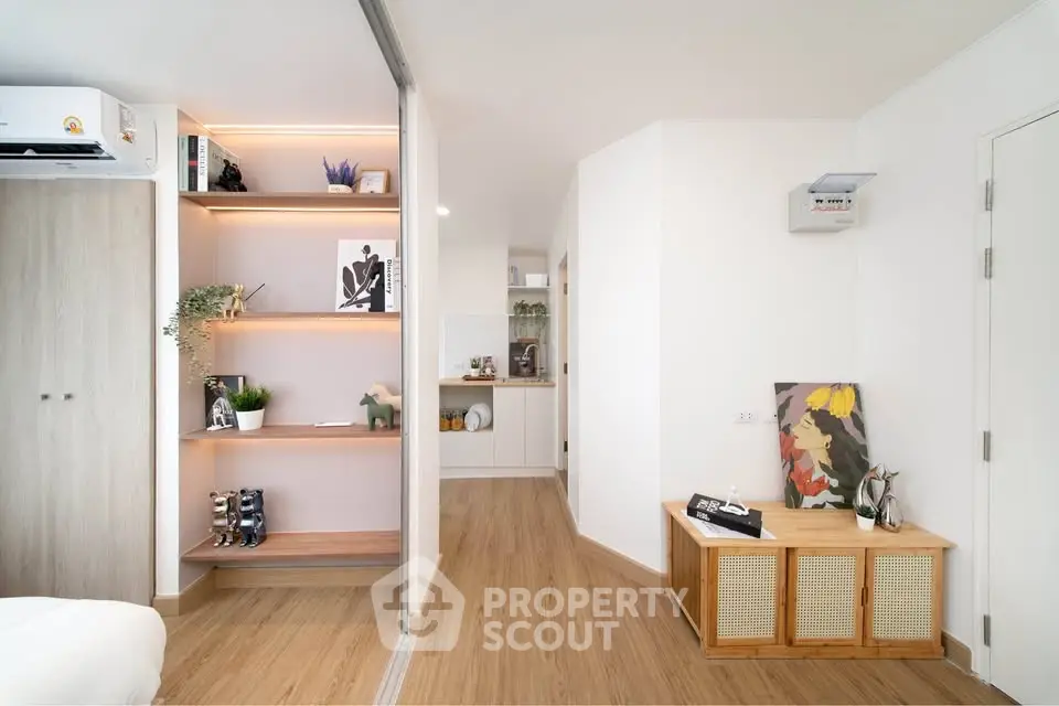 Modern living space with stylish decor and wooden flooring, featuring open shelving and contemporary design.