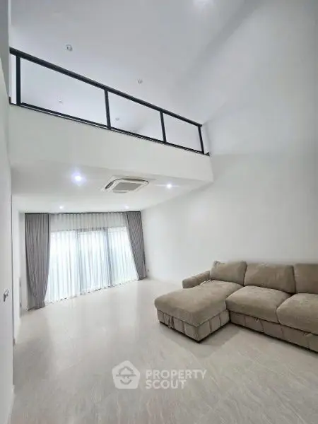 Spacious modern living room with high ceiling and elegant sofa