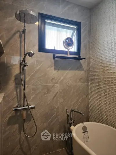 Modern bathroom with elegant shower and freestanding bathtub, featuring stylish tile design and natural light.