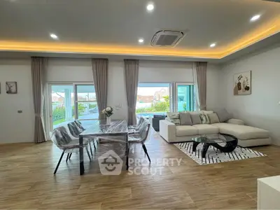 Spacious modern living room with elegant decor and large windows offering natural light.