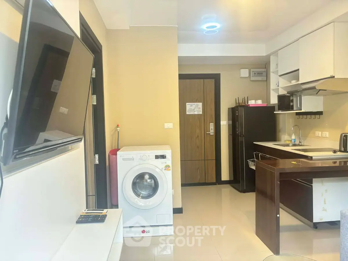 Modern apartment interior with kitchen and washing machine, featuring sleek design and contemporary appliances.
