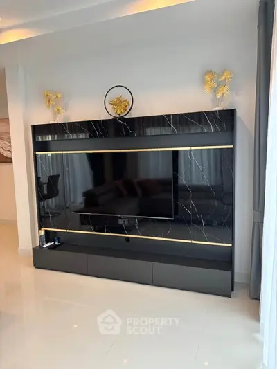 Modern living room with sleek black marble TV wall unit and elegant decor accents.