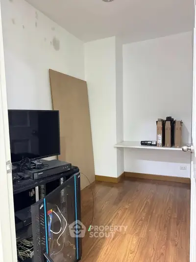 Compact study room with wooden flooring and minimal setup, ideal for home office or small workspace.