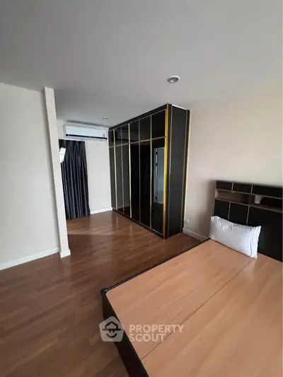 Spacious bedroom with modern wardrobe and wooden flooring